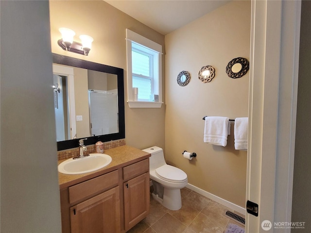 bathroom with toilet, baseboards, vanity, tile patterned floors, and a shower
