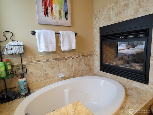 bathroom with a garden tub and a multi sided fireplace