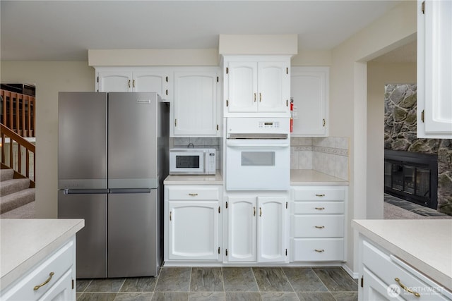 3579 NW Dodson Rd, Ephrata, WA 98823 - kitchen featuring white appliances, white cabinets, light countertops, and backsplash