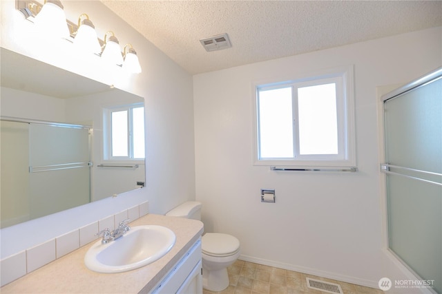 3579 NW Dodson Rd, Ephrata, WA 98823 - bathroom featuring vanity, toilet, a textured ceiling, a shower with door, and baseboards