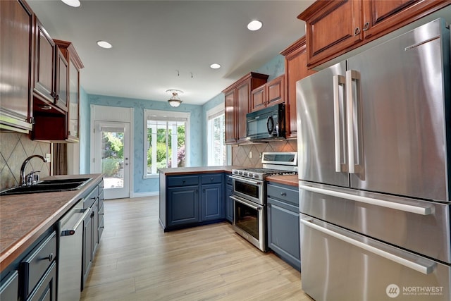 18423 Hawksview Dr, Arlington, WA 98223 - kitchen with appliances with stainless steel finishes, light wood finished floors, a sink, a peninsula, and recessed lighting