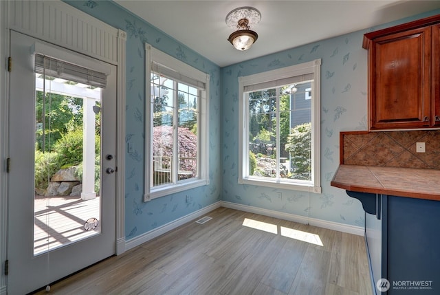 18423 Hawksview Dr, Arlington, WA 98223 - unfurnished dining area with light wood-style floors, wallpapered walls, and baseboards