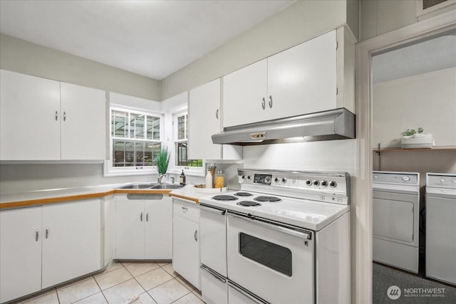 kitchen featuring white range with electric stovetop, under cabinet range hood, separate washer and dryer, a sink, and white cabinetry