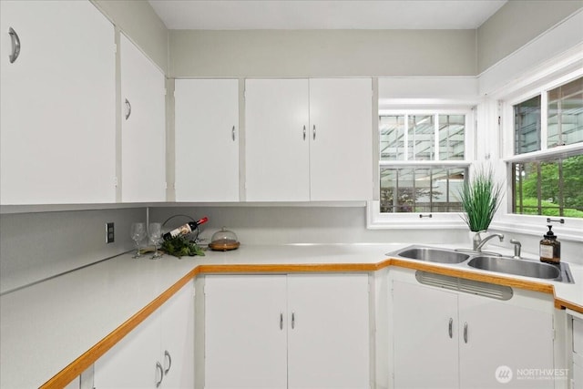 kitchen featuring a sink, light countertops, and white cabinets