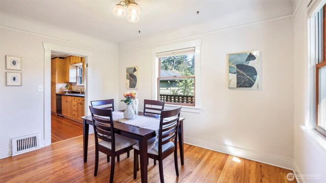 10735 Whitman Ave N, Seattle, WA 98133 - dining space featuring baseboards, light wood finished floors, a chandelier, and ornamental molding