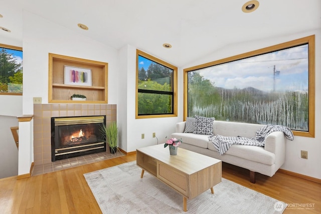 8840 NE 24th St, Clyde Hill, WA 98004 - living area with vaulted ceiling, wood finished floors, a tile fireplace, and baseboards