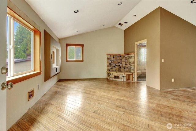 unfurnished living room with plenty of natural light, vaulted ceiling, and wood finished floors