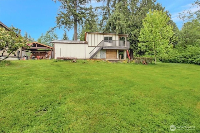 back of property featuring stairway, a lawn, and a deck