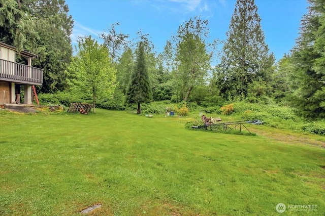 view of grassy yard featuring a deck