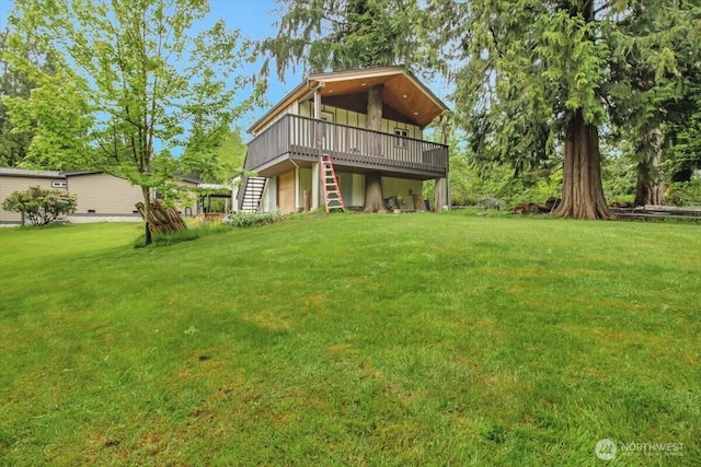rear view of property featuring a deck, a lawn, and stairway