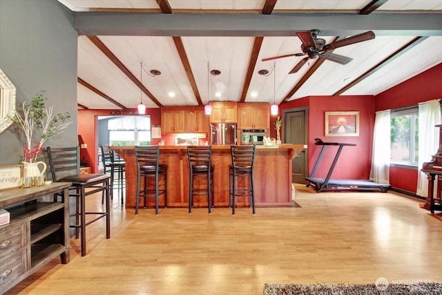 kitchen featuring appliances with stainless steel finishes, light wood-type flooring, plenty of natural light, a breakfast bar, and recessed lighting