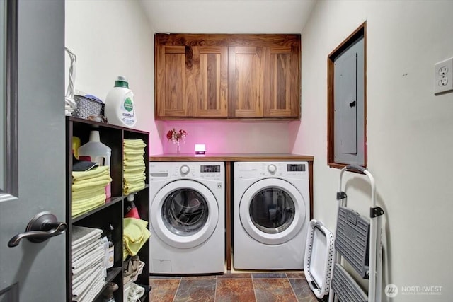 laundry room with cabinet space, washing machine and clothes dryer, electric panel, and dark stone finish flooring