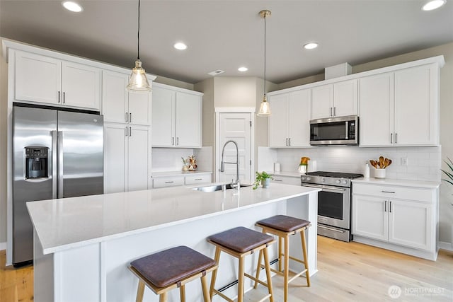 17711 11th Ave NE, Arlington, WA 98223 - kitchen with stainless steel appliances, a sink, light wood-style flooring, white cabinetry, and recessed lighting
