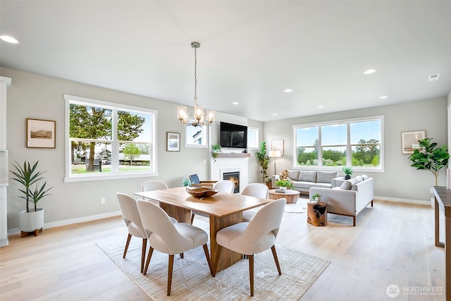 17711 11th Ave NE, Arlington, WA 98223 - dining area featuring a large fireplace, light wood-style floors, a chandelier, baseboards, and recessed lighting