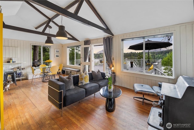 living area with hardwood / wood-style flooring, wooden walls, beamed ceiling, and high vaulted ceiling