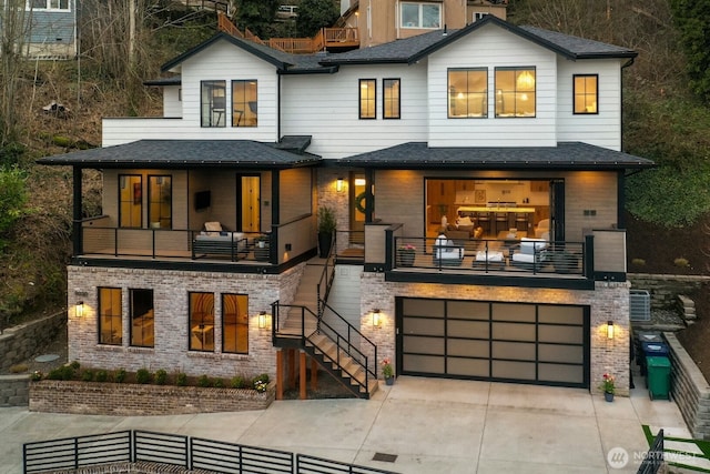 modern home with a balcony, an attached garage, and concrete driveway