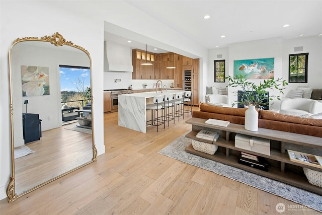 living area featuring light wood-type flooring and recessed lighting