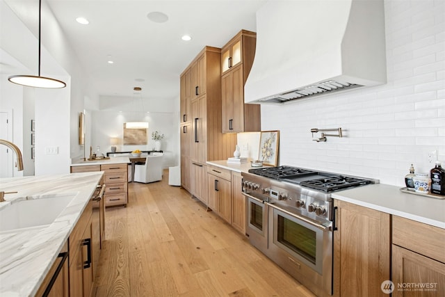 kitchen featuring custom range hood, range with two ovens, a sink, tasteful backsplash, and glass insert cabinets