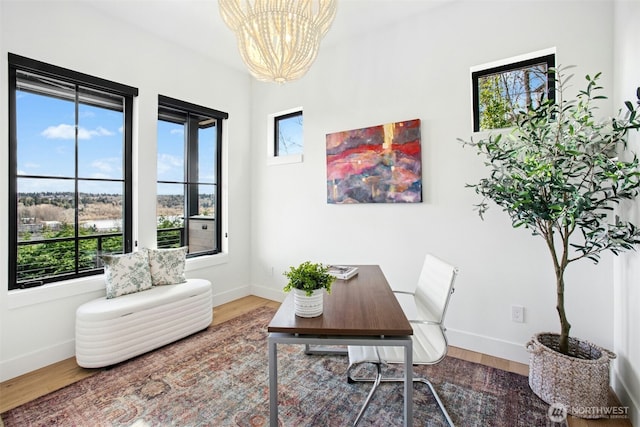 office area with a chandelier, baseboards, and wood finished floors