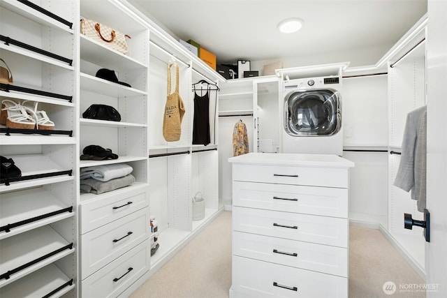 walk in closet featuring washer / clothes dryer and light colored carpet