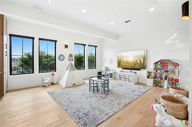 recreation room with hardwood / wood-style floors, recessed lighting, and baseboards