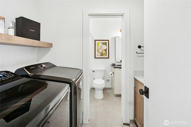 laundry room with separate washer and dryer and light tile patterned flooring