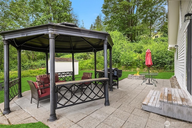 23516 20th Ave W, Bothell, WA 98021 - view of patio / terrace with a fire pit, outdoor dining area, a gazebo, a storage unit, and an outbuilding