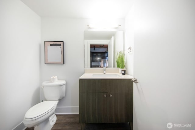 530 Broadway E Unit 124, Seattle, WA 98102 - half bathroom featuring toilet, baseboards, vanity, and wood finished floors