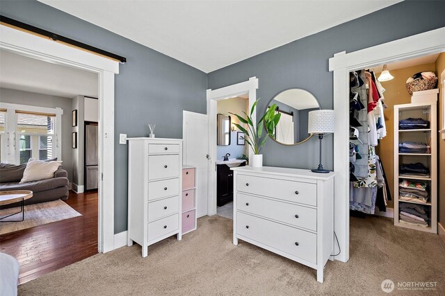 6311 46th Ave SW, Seattle, WA 98136 - bedroom featuring light carpet, a sink, and baseboards