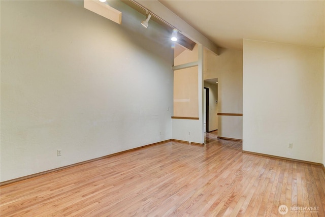 6605 Cooper Point Rd NW, Olympia, WA 98502 - unfurnished room with wood finished floors, rail lighting, and baseboards