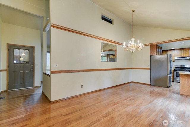 6605 Cooper Point Rd NW, Olympia, WA 98502 - unfurnished dining area with light wood finished floors, a chandelier, high vaulted ceiling, and baseboards