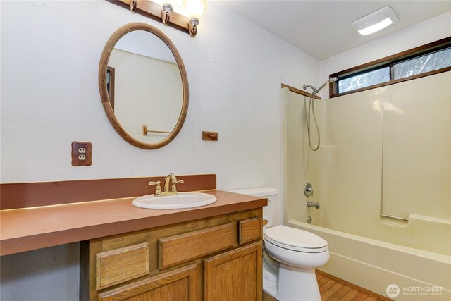 6605 Cooper Point Rd NW, Olympia, WA 98502 - bathroom with toilet, vanity, wood finished floors, and bathing tub / shower combination