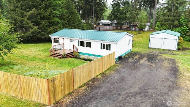 view of front of home with an outbuilding, a wooden deck, metal roof, and a detached garage