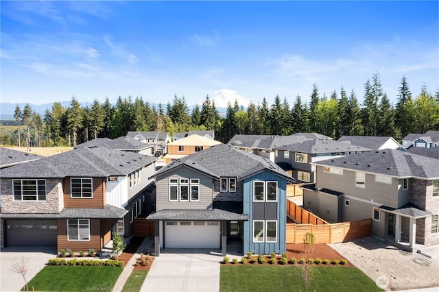 view of front of property with driveway, an attached garage, a residential view, and board and batten siding