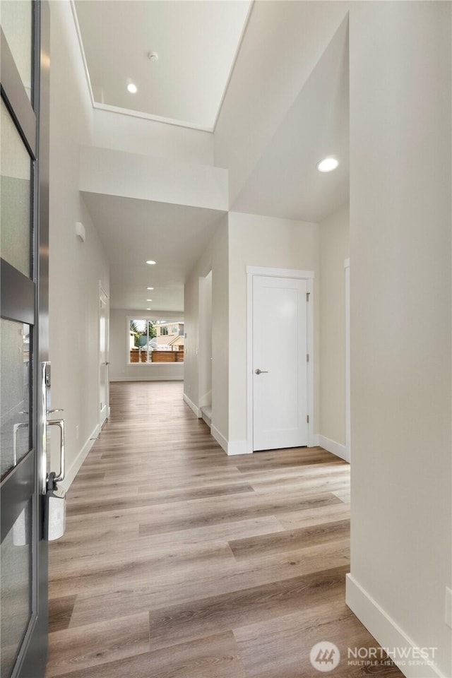 foyer entrance with light wood-style floors, baseboards, and recessed lighting