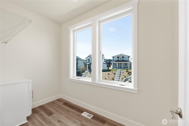 spare room with baseboards and wood finished floors