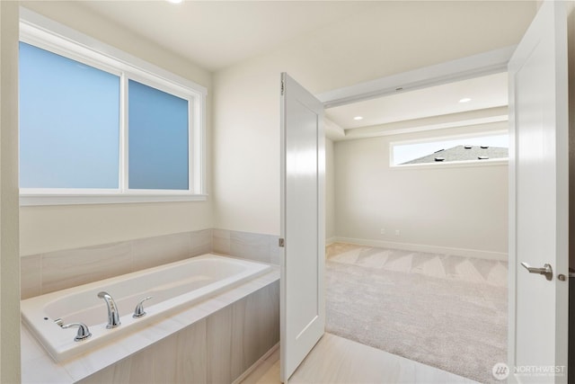 bathroom with a garden tub and recessed lighting
