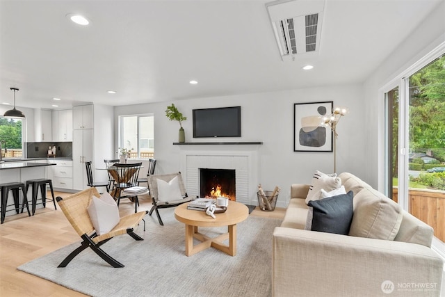 4257 33rd Ave W, Seattle, WA 98199 - living area featuring plenty of natural light, a brick fireplace, recessed lighting, and light wood-style floors