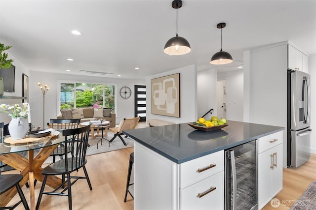 4257 33rd Ave W, Seattle, WA 98199 - kitchen with beverage cooler, stainless steel fridge with ice dispenser, dark countertops, light wood finished floors, and recessed lighting