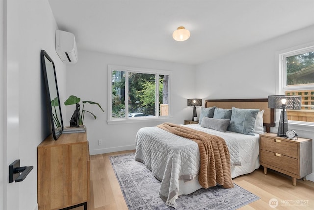 4257 33rd Ave W, Seattle, WA 98199 - bedroom with a wall mounted AC, light wood-type flooring, and baseboards