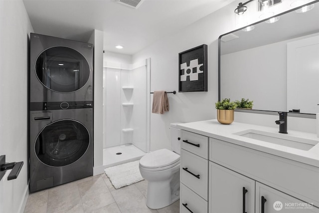 4257 33rd Ave W, Seattle, WA 98199 - bathroom featuring estacked washer and dryer, toilet, a shower stall, vanity, and tile patterned floors