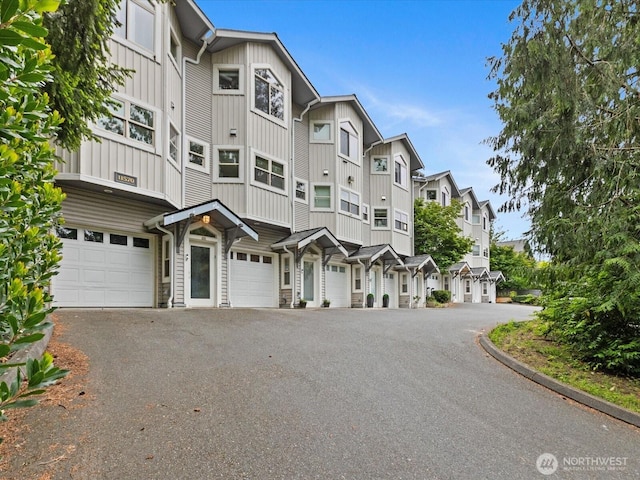 11570 Stone Ave N Unit A-102, Seattle, WA 98133 - view of front of home featuring board and batten siding, a residential view, driveway, and an attached garage
