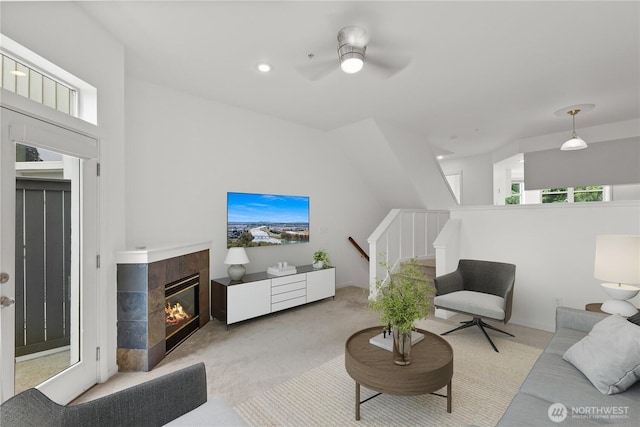 11570 Stone Ave N Unit A-102, Seattle, WA 98133 - living room featuring light colored carpet, a tiled fireplace, and a ceiling fan