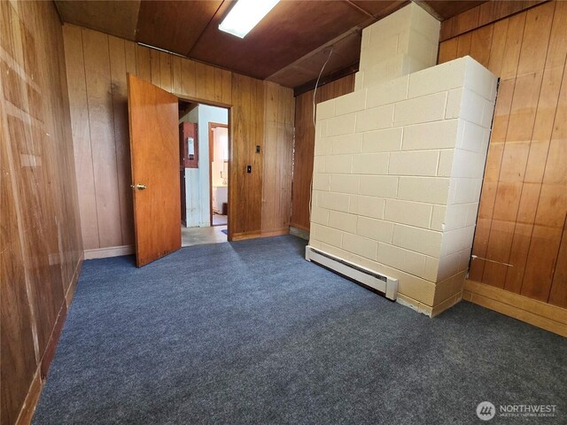 810 H St, Forks, WA 98331 - spare room with a baseboard radiator, wood walls, and carpet flooring