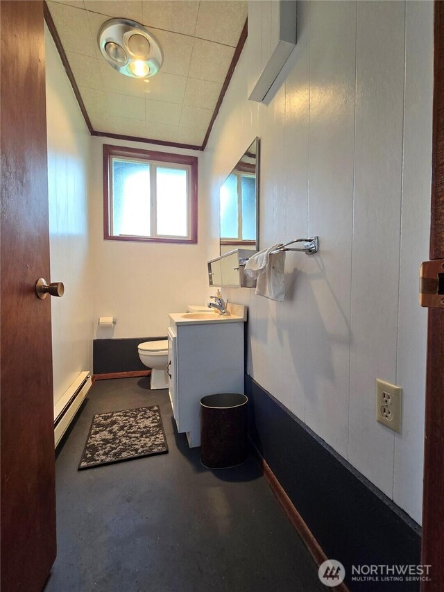 810 H St, Forks, WA 98331 - half bathroom featuring baseboard heating, concrete floors, vanity, toilet, and crown molding