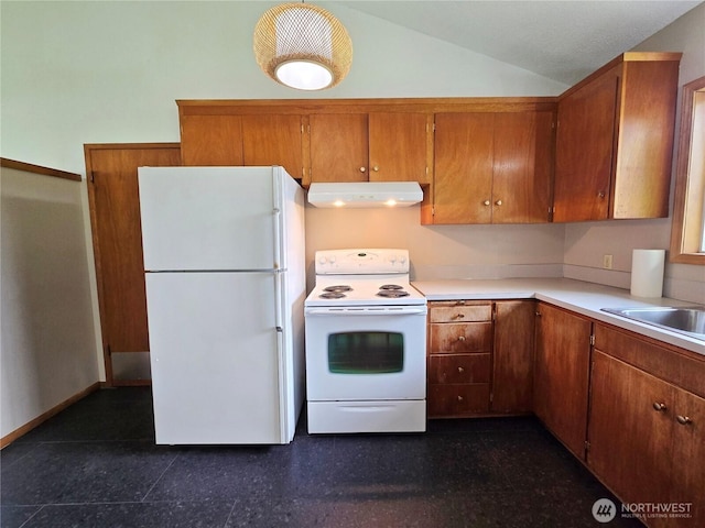 810 H St, Forks, WA 98331 - kitchen featuring white appliances, under cabinet range hood, brown cabinets, vaulted ceiling, and light countertops