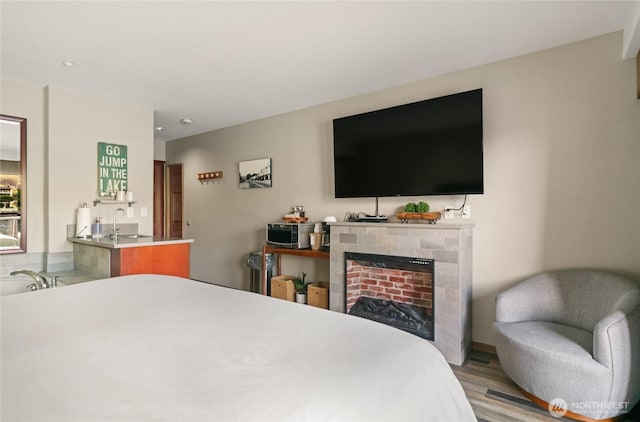 322 W Woodin Ave Unit 711, Chelan, WA 98816 - bedroom featuring wood finished floors, a tile fireplace, a sink, and recessed lighting