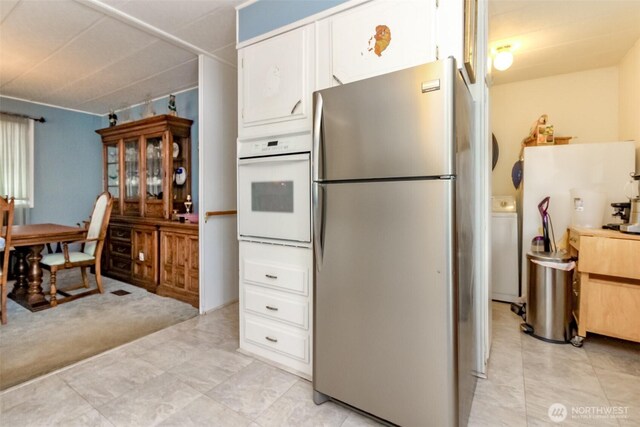 2101 S 324th St Unit 136, Federal Way, WA 98003 - kitchen with freestanding refrigerator, white oven, white cabinetry, and washer / clothes dryer
