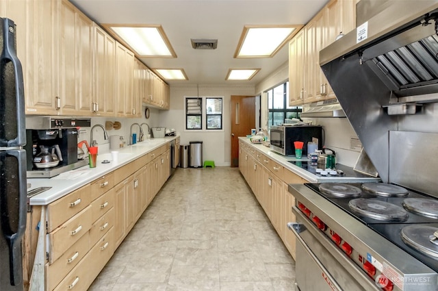 2101 S 324th St Unit 136, Federal Way, WA 98003 - kitchen with stainless steel microwave, range, light brown cabinetry, and light countertops