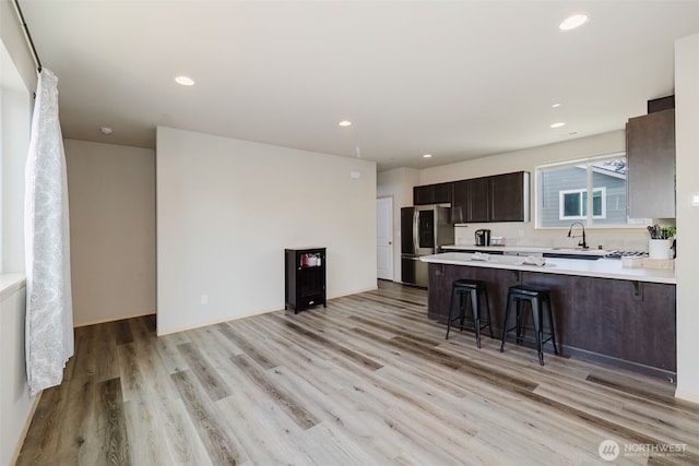 2450 Zeeden Way, Bremerton, WA 98310 - kitchen featuring smart refrigerator, a sink, light countertops, a breakfast bar, and light wood finished floors